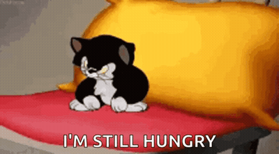 Black And White Cartoon Cat On Red Blanket Next To Yellow Pillow GIF