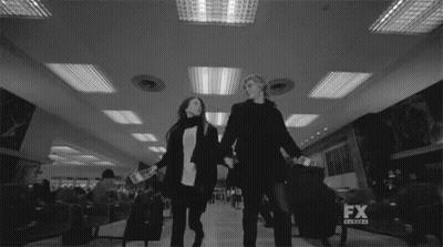Black And White Couple Holding Hands At Airport GIF