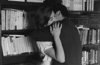 Black And White Couple Kissing By Bookshelf GIF