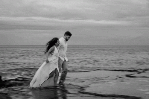 Black And White Couple Walking On Beach GIF