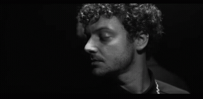 Black And White Curly Haired Man Looking At Another GIF
