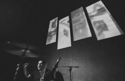 Black And White Drummer With Wall Of Images GIF