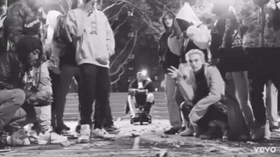 Black And White Group Standing Around Wheelchair GIF