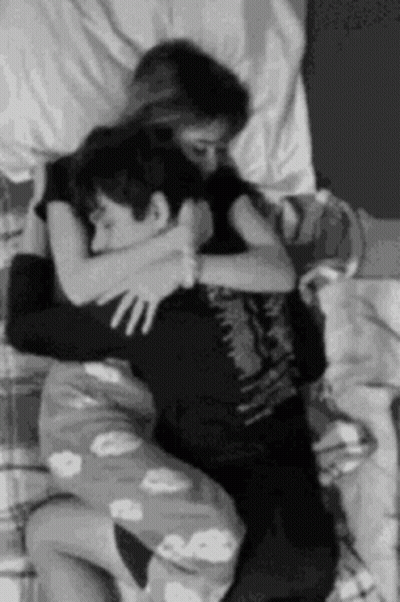Black And White Man And Woman Hugging In Bed GIF