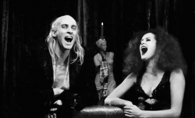Black And White Man And Woman Laughing In Front Of Statue GIF