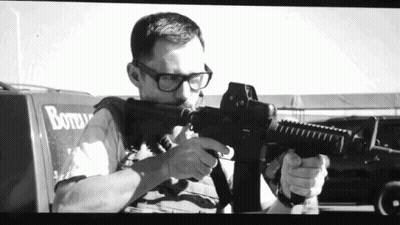 Black And White Man Holding Gun By Bottle Truck GIF