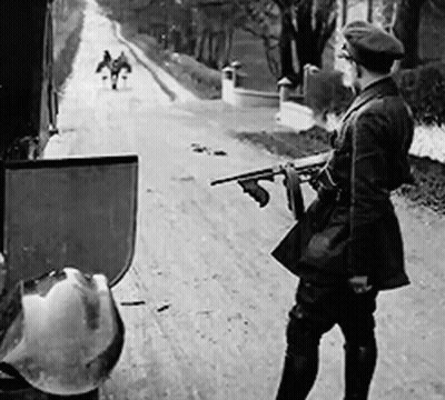 Black And White Man Holding Gun On Dirt Road GIF