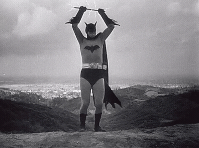 Black And White Man In Batman Costume Holding Bat GIF