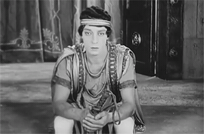 Black And White Man In Costume Sitting GIF