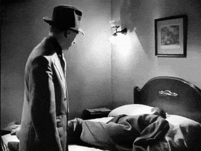 Black And White Man In Suit And Hat Next To Bed GIF