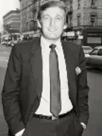 Black And White Man In Suit And Tie On City Street GIF