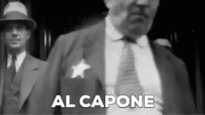 Black And White Man In Suit And Tie With Sheriff's Badge GIF
