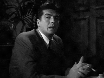 Black and White Man in Suit Smoking Cigarette