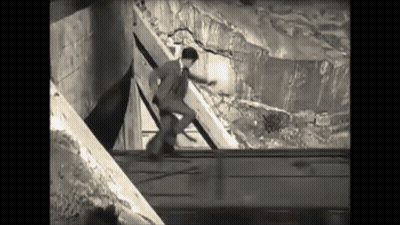 Black And White Man In Suit Standing On Railing GIF