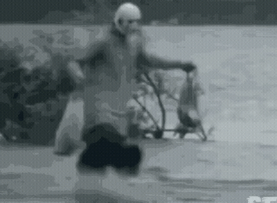 Black And White Man Riding Bike On Snowy Road GIF