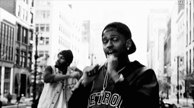 Black And White Man Singing Into Microphone On City Street GIF