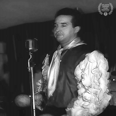 Black And White Man Singing Into Microphone With Laurel Wreath GIF