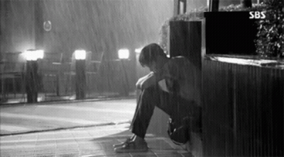 Black And White Man Sitting In Rain Head Down GIF
