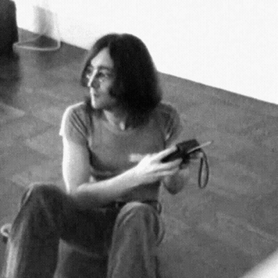 Black And White Man Sitting On Floor Holding Camera GIF