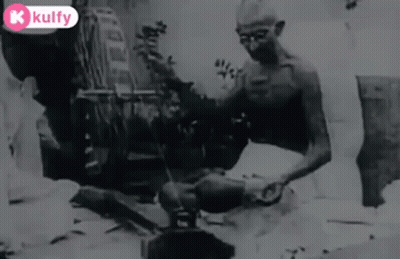 Black And White Man Sitting On Ground With Broom GIF