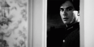 Black And White Man Standing In Doorway Looking Out GIF