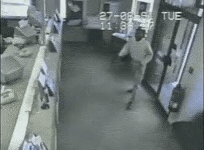 Black And White Man Walking Down Hallway With Tue GIF