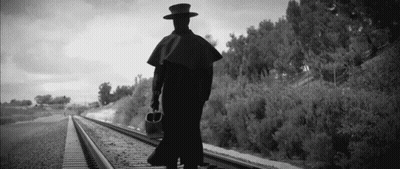 Black And White Man Walking On Train Tracks GIF
