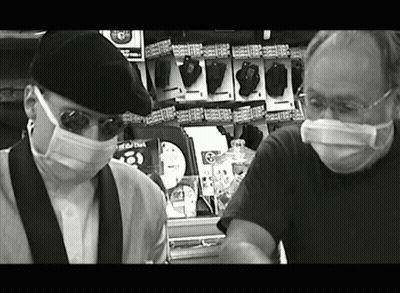 Black And White Men In Masks Near Remote Controls GIF