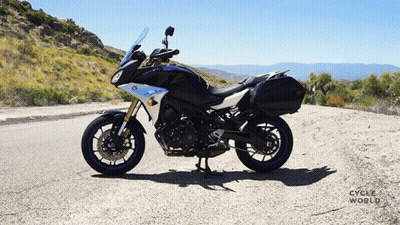 Black And White Motorcycle Parked On Road With Cycle World GIF