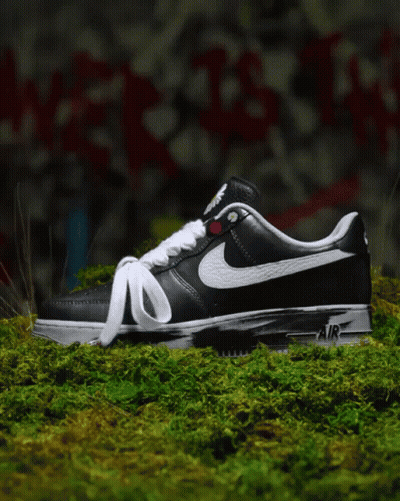 Black And White Nike Air Shoes On Mossy Surface GIF