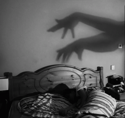 Black And White Person Laying On Bed With Hand Shadow GIF