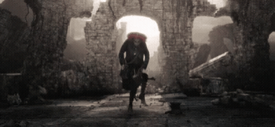 Black And White Photo Man Carrying Backpack And Gun In Tunnel GIF
