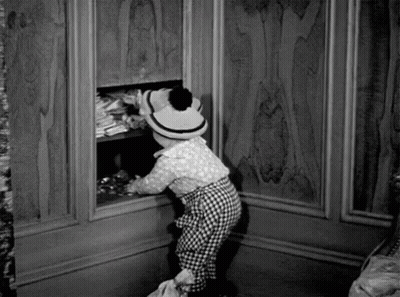 Black And White Photo Of Little Girl In Hat Looking Into Closet GIF