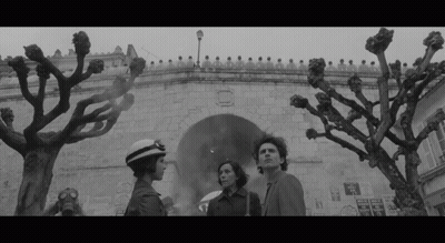 Black And White Photo Of Man And Two Women In Front Of Building GIF