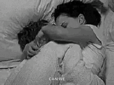 Black And White Photo Of Man And Woman Hugging In Bed GIF