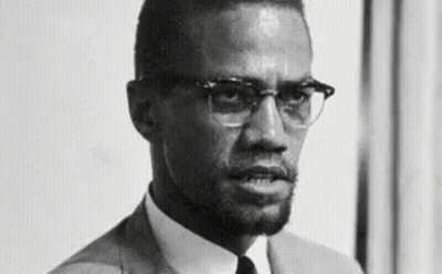 Black And White Photo Of Man In Suit And Tie With Glasses GIF