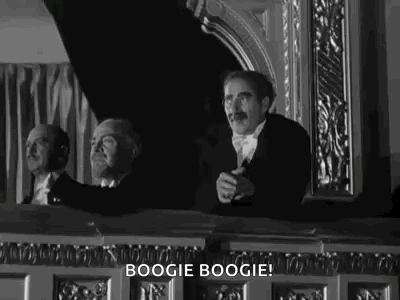 Black And White Photo Of Man In Tuxedo Sitting In Balcony GIF
