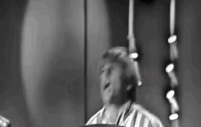 Black And White Photo Of Man Playing Drum Set On Stage GIF