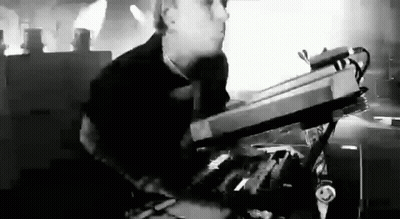 Black And White Photo Of Man Playing Keyboard On Stage GIF