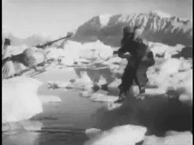 Black And White Photo Of Man Standing On Ice With Mountains GIF