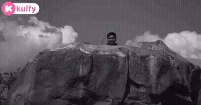 Black And White Photo Of Man Standing On Rock GIF