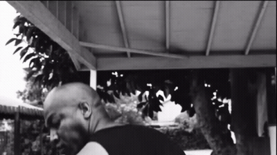 Black And White Photo Of Man Under Porch With Tree GIF