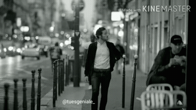 Black And White Photo Of Man Walking Down Street GIF