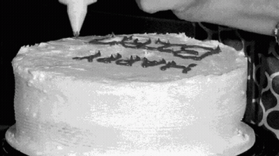 Black And White Photo Of Person Frosting Cake GIF