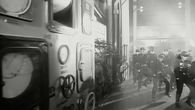 Black And White Photo Of Police Officers Running In Front Of Building GIF