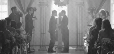 Black And White Photo Of Two Men Kissing At Wedding GIF