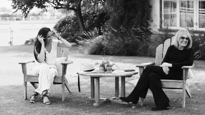 Black And White Photo Of Two Women Sitting On Lawn Chairs GIF