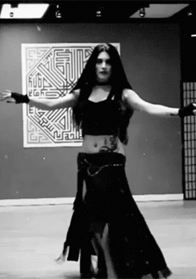 Black And White Photo Of Woman Dancing In Front Of Wall Saying Rubl GIF