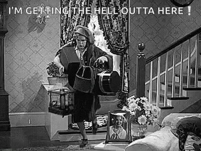 Black And White Photo Of Woman Holding Bag In Living Room GIF