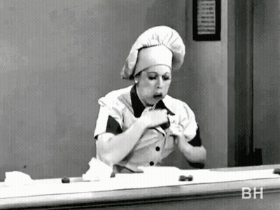 Black And White Photo Of Woman In Chef Hat Eating GIF
